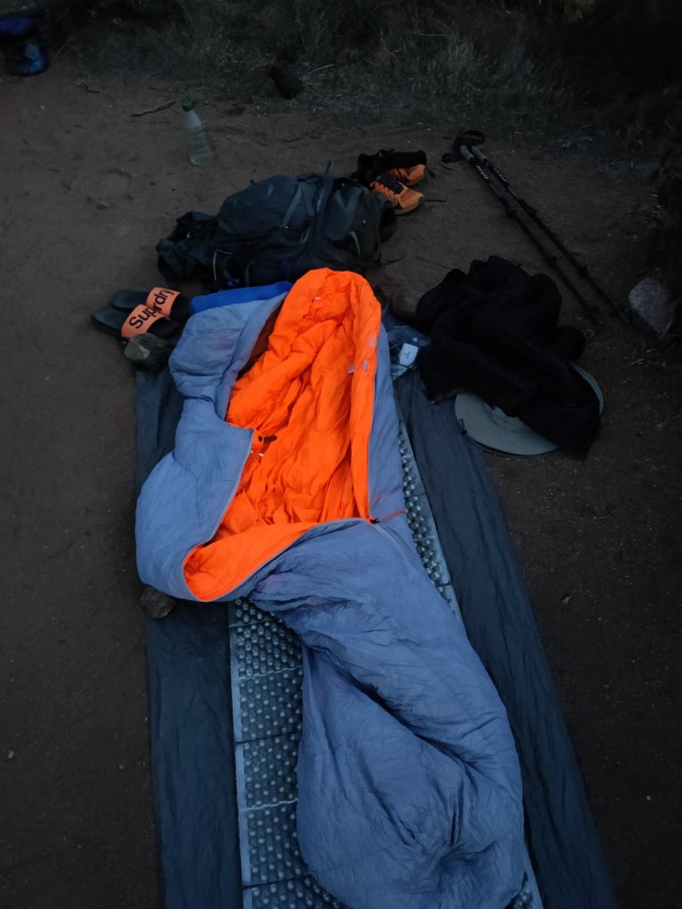 Sleeping bag on the ground, kinda dirty.
