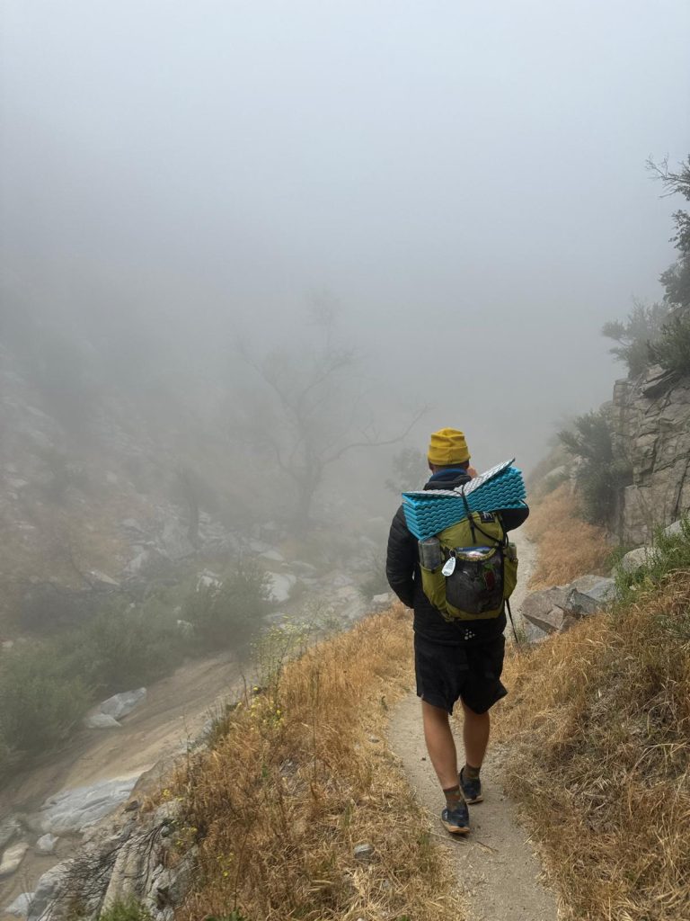 Hiker walking in to the fog.